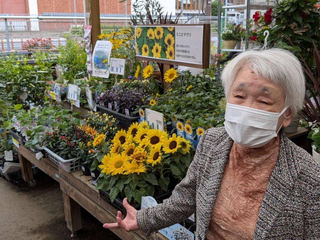 お買い物レクリエーション　花屋でヒマワリを前に笑顔　ファミリーケア心の家 久が原