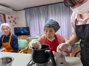 ②茹でる:スタッフと一緒に白玉団子を茹でるご利用者様 手作りおやつ ファミリーケア心の家 上池台