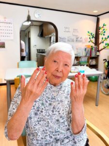 星模様:赤に星模様のネイルを楽しむご利用者様 ネイルレクリエーション 大田区上池台のデイサービス