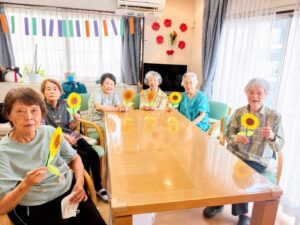 完成した手作りのひまわりを手に笑顔の利用者様 夏の創作活動 大田区上池台のデイサービス ファミリーケア心の家 上池台