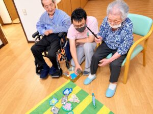 スタッフのサポートで手作りの魚釣りゲームを楽しむ利用者様 大田区上池台のデイサービス ファミリーケア心の家 上池台