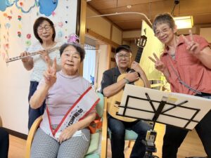ボランティア演奏家の皆様とお誕生日の利用者様の記念撮影 音楽会 ファミリーケア心の家 上池台